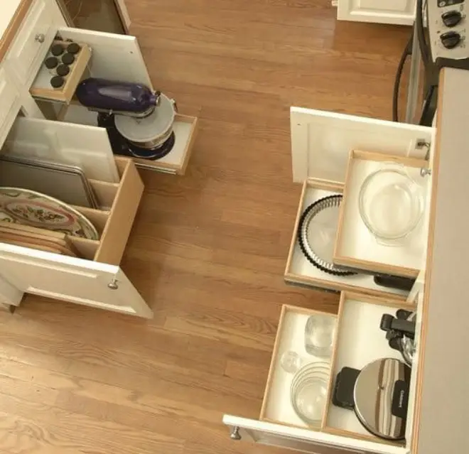 Kitchen cabinets opened with pots and pans organizers pulled out.