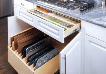 A lower kitchen cabinet with two Pull Out shelves, one for spices and one for pans and baking trays.