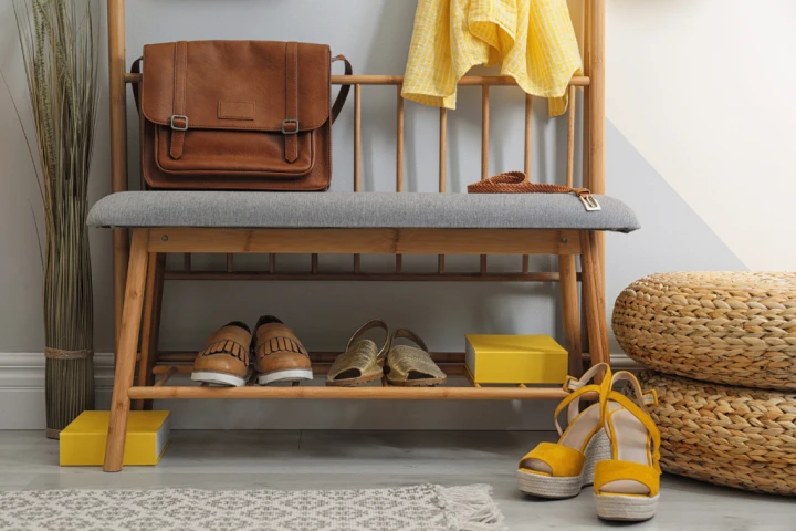 Shoes resting on the bottom shelf of a wooden bench.