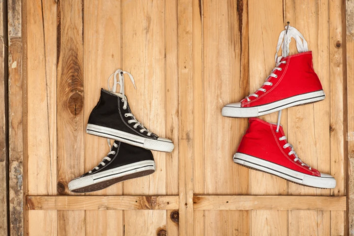 Vibrant red and black shoes hanging behind the door.