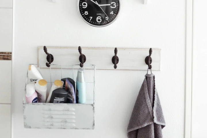 a bathroom with a clock and a towel.