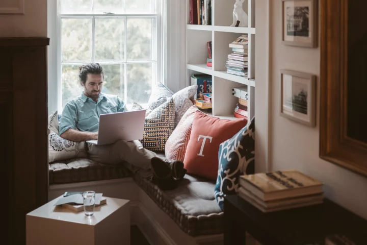 A person sitting on a couch using a laptop.