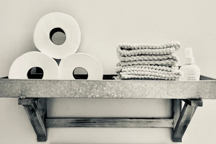 A stack of toilet paper and towels on a shelf.