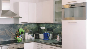 white wooden kitchen cabinet with blue and white electric kettle.