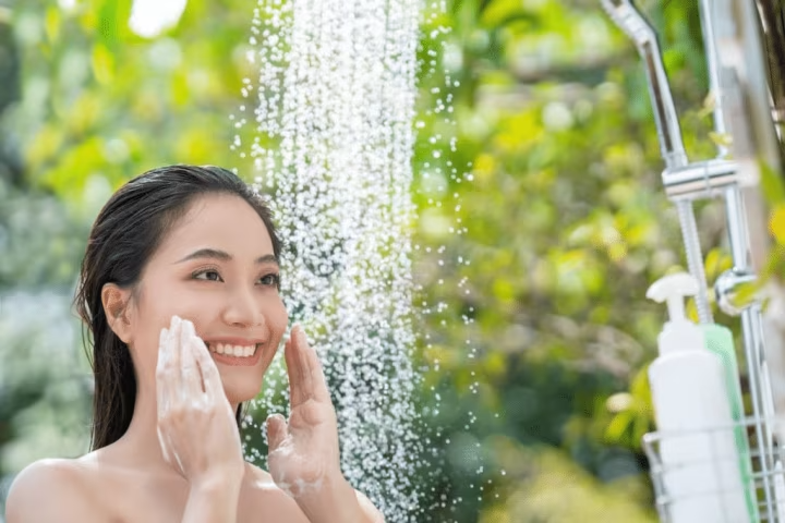 Image of a woman standing under shower.