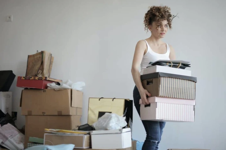 A person carrying boxes in a room.